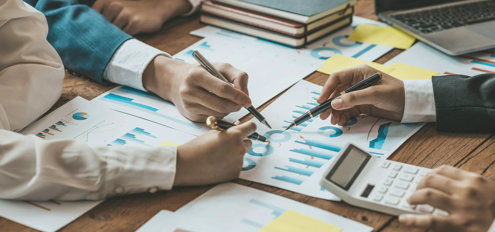 kalkulator, długopisy w dłoniach